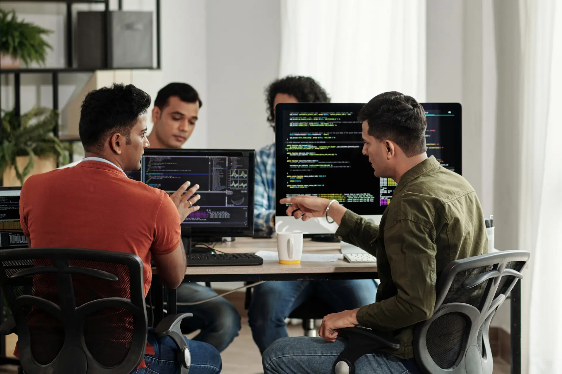 IT Workers collaborating on a code review in an office setting