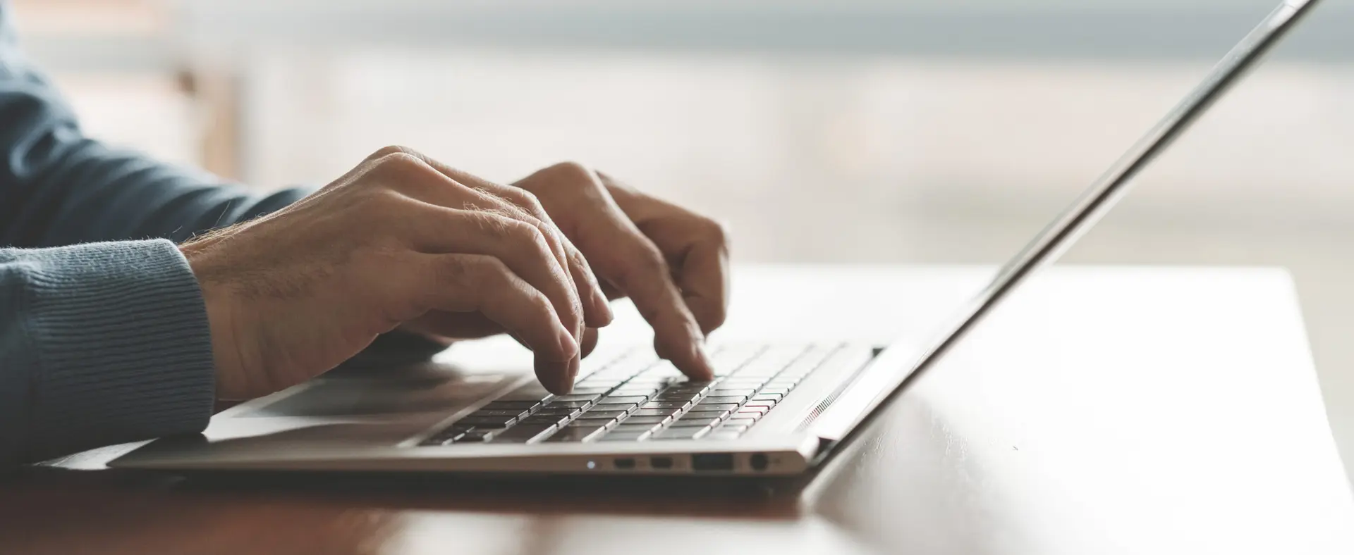 Hands typing on a laptop